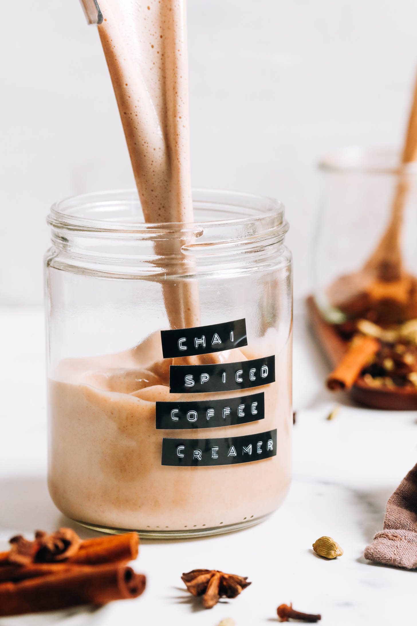 Pouring dairy-free chai-spiced coffee creamer into a glass jar